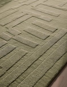 a green rug with squares and rectangles on it