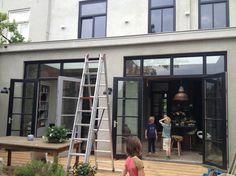 two children are standing in the back door of a house