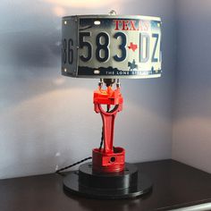 a lamp that is sitting on top of a table with a license plate underneath it