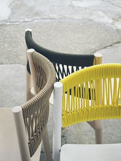 three chairs with different colored seats on them