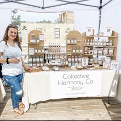 a woman standing next to a table full of products