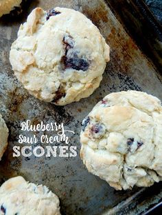 blueberry sour cream scones on a baking sheet with the words, blueberry sour cream scones