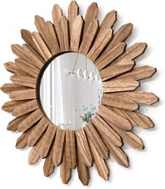 a wooden sunburst mirror hanging on the wall