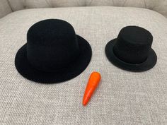 two hats and a carrot sitting on a couch