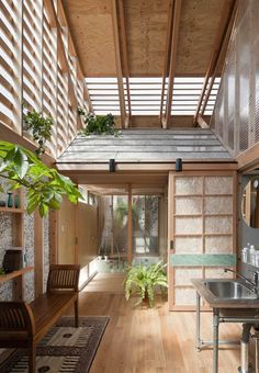 the inside of a house with wood flooring and wooden walls, windows, and plants