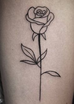 a black and white rose tattoo on the side of a woman's thigh,