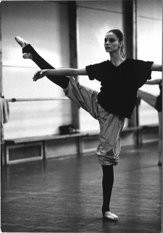 a woman is doing an acrobatic move in a dance studio