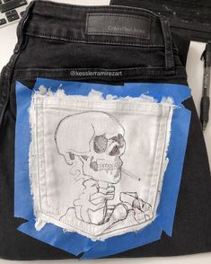 a drawing of a skeleton on the back of a pair of jeans with torn edges