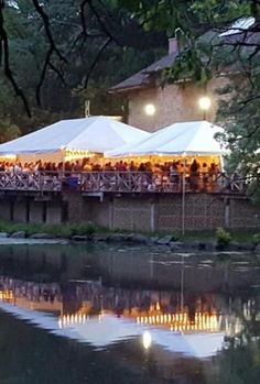 a large tent set up on the side of a river