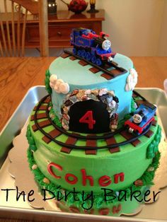 a birthday cake that is shaped like a train on top of a table with the number four