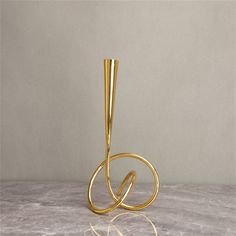 a gold metal object sitting on top of a marble counter next to a white wall