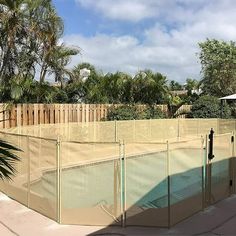 a fenced in swimming pool surrounded by palm trees