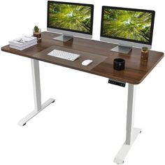 two computer monitors sitting on top of a wooden desk next to each other with keyboard and mouse