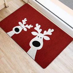 a red door mat with two white reindeer heads on the front and back of it