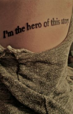 a woman with a tattoo on her back saying i'm the hero of this story