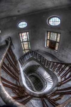 an old spiral staircase with three windows