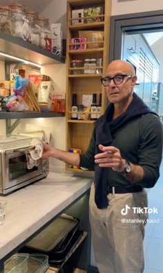 a man standing in front of a counter with a toaster oven on top of it