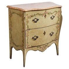 an old dresser with flowers painted on the top and drawers, is isolated against a white background