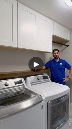 a man standing next to a washer and dryer