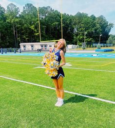 a cheerleader standing in the middle of a field