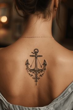 an anchor tattoo on the back of a woman's shoulder