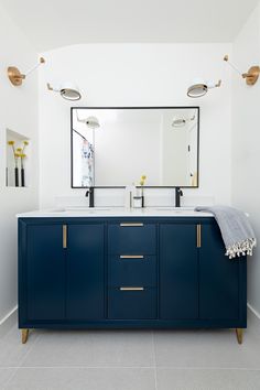 a bathroom with two sinks and a large mirror on the wall above it's counter