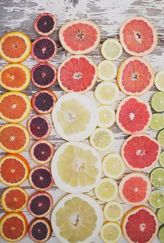 various citrus fruits are arranged on a wooden surface