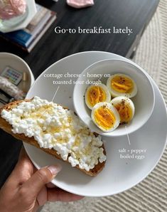 a person holding a plate with eggs and cottage cheese on toasted sourdough