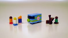 there are many different legos on the table and one is blue, green, yellow, pink