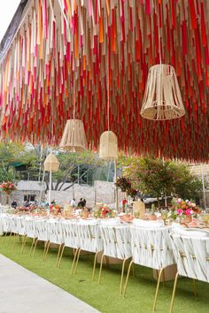 a long table covered in lots of paper streamers hanging from it's ceiling