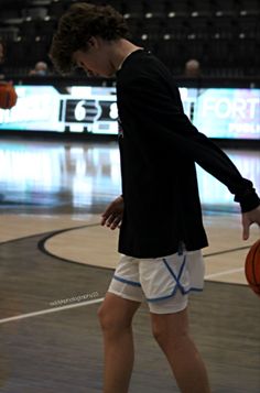 a man standing on top of a basketball court with a ball in his hand next to him