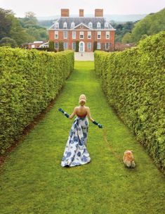 a woman is walking her dog in the grass