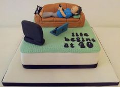 a birthday cake with a man laying on a couch in the living room and writing life begins at 40