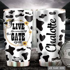 two white and black cups with the words live the moment at the gate open