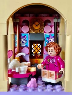 there is a small lego kitchen set in the playroom with pink walls and purple flooring