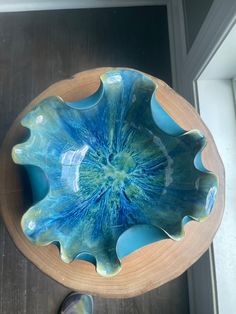 a blue bowl sitting on top of a wooden table next to a pair of shoes