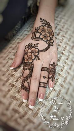 a woman's hand with henna tattoos on it