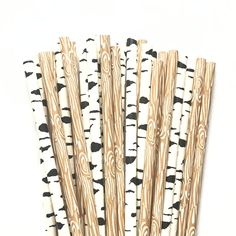 several wooden sticks with black and white designs are lined up in a row on a white surface