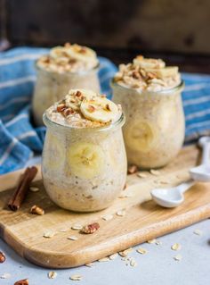 two jars filled with oatmeal and bananas on top of a cutting board