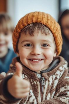 a young boy giving the thumbs up sign