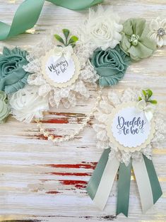 three ribbons with flowers on them sitting next to each other in front of a wooden background