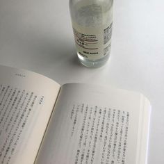 an open book sitting on top of a table next to a glass filled with water