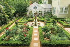 a garden with lots of flowers and plants in the center, surrounded by greenery