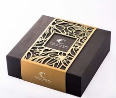 a black and gold gift box with an intricate design on the front, inside it