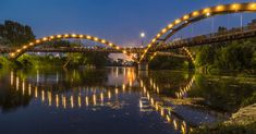 an illuminated bridge over a river at night