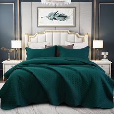 the bed is made with green bedspread and pillows