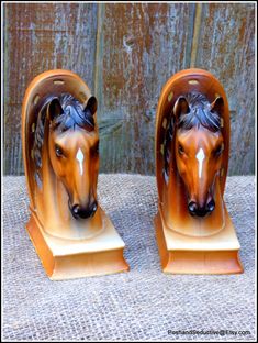 two ceramic horse heads sitting on top of each other