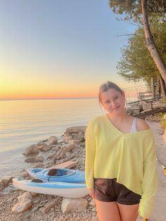 a woman standing next to a body of water