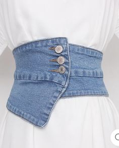 a woman wearing a white shirt and blue jean skirt with buttons on the back of her waist