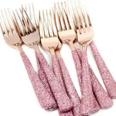 five pink glittered forks are lined up next to each other on a white background